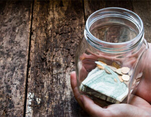 hands holding jar of loose change